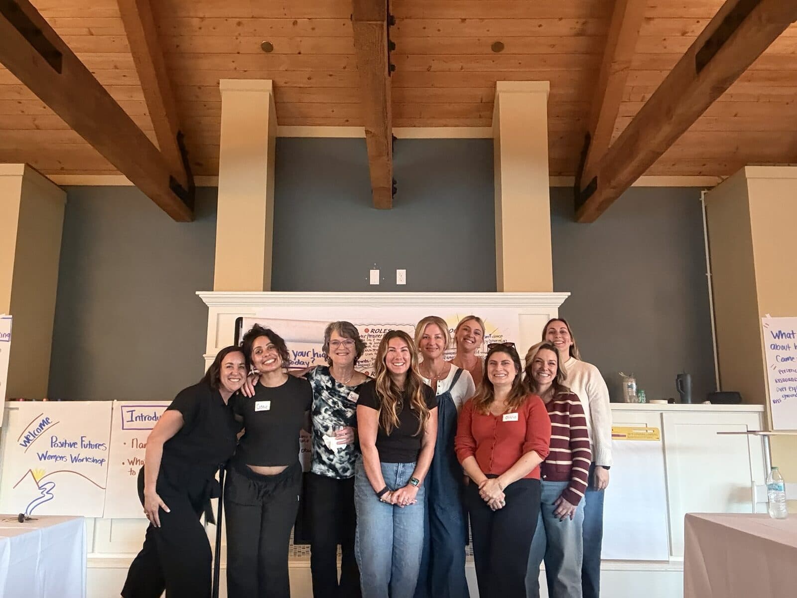 The workshop group standing together in front of the fireplace, name tags on